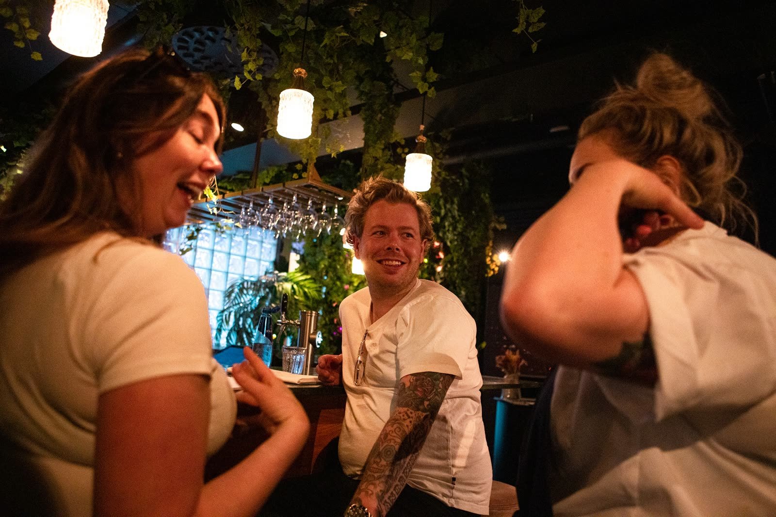 Tre venner ler sammen i baren på Bula