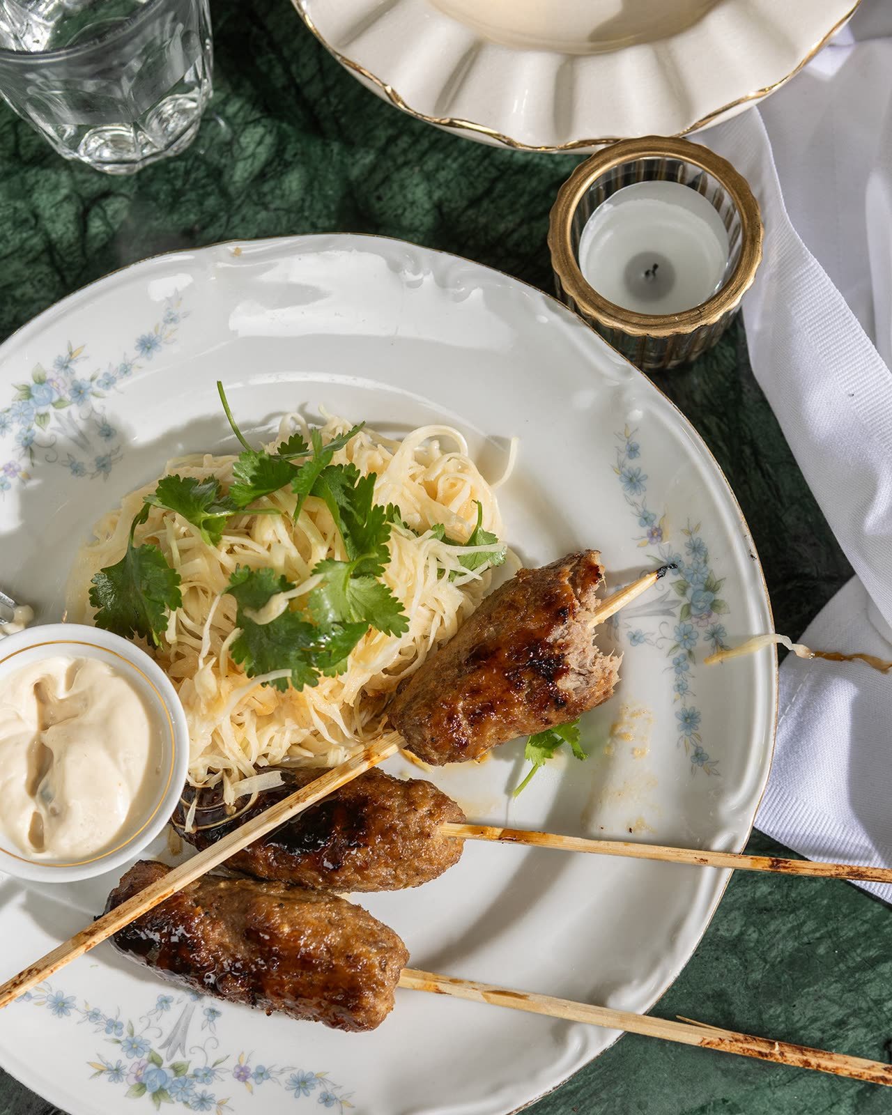 Kebabspyd og pasta på et porselensfat